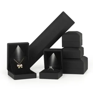 Ensemble de boîtes à bijoux LED noires avec éclairage pour bagues et colliers.
