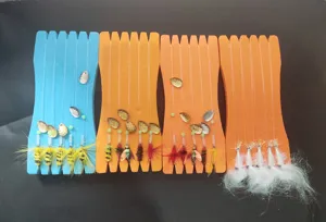 Vista detallada del juego de micro señuelos, con moscas coloridas y bobinas de espuma.