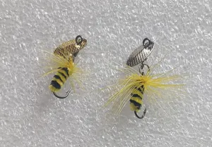 Detailed view of bulk bee fly fishing lures, bionic insect trout hooks with feathers and spinner blades.