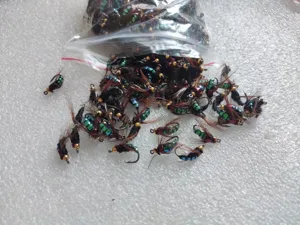Vista detallada de anzuelos de pesca con mosca biónicos y señuelos para micro pesca.