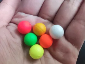 Detail view of 12mm foam fishing float balls, colorful buoyant beads for carp angling tackle.
