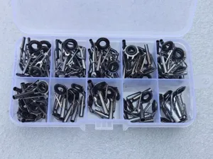 Detail view of stainless steel ceramic fishing rod guide rings neatly sorted in a clear storage box.