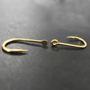 Golden fishing hooks comparison set featuring flattened and ringed eyed hook designs for tackle.