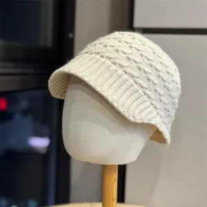 Detailed view of a stylish beige knitted visor winter hat, showing cozy texture and knit pattern.