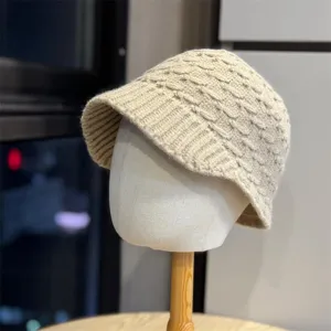 Detailed view of the cozy beige knit bucket hat texture showing warm autumn winter style.
