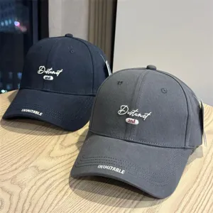Close-up detail of stylish embroidered baseball caps with distinct letters, premium cotton fabric.