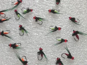 Detail shot of artificial fly fishing hooks with red beads and feathers for micro luring.