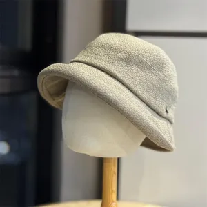 Detailed view of casual beige woven pleated bucket hat, stylish spring accessory texture.