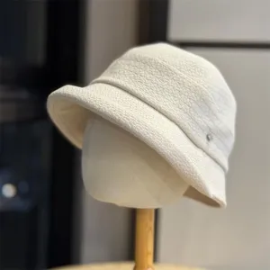 Close-up detail of the casual pleated bucket hat fabric and texture, off-white color.
