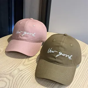 Close-up detail of casual cotton baseball cap featuring stylish white script embroidery.