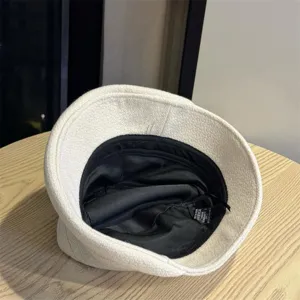 Detail view of the casual off-white tweed bucket hat, featuring interior black lining.