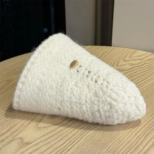 Detail view of a stylish off-white knit fisherman hat, showcasing soft texture and cozy wear.