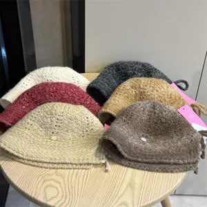 Detailed view of multiple knit bucket hats in various colors arranged neatly on a wooden table.