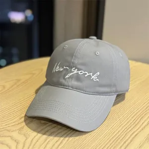Detail view of a stylish grey cotton baseball cap with white New york embroidered lettering.