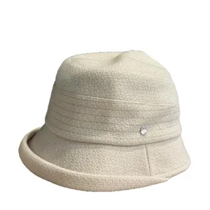 Beige woven bucket hat for women, casual outdoor sun hat with stylish band and metal charm.