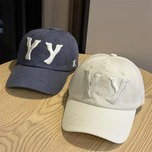 Close up view of vintage cotton baseball caps with 3D embroidery YY letters detail.