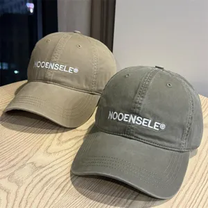 Close-up details of washed cotton baseball cap with stylish embroidered logo and curved brim.