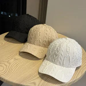 Primo piano di tre cappelli da baseball casual con caratteristica trama stropicciata sul tavolo.