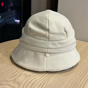 Minimalist solid color short brim pleated bucket hat with metal detail for autumn.