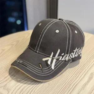 Detailed view of vintage embroidered baseball hat showing contrast stitching and distressed brim.