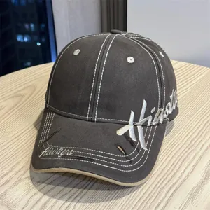 Vintage distressed baseball cap detail shot featuring contrast white stitching and embroidery.