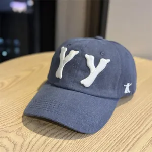 Close-up view of dark blue cotton baseball cap showcasing white 3D embroidered YY letters.