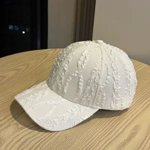 Vista dettagliata di un cappello da baseball plissettato bianco da donna, casual e chic.