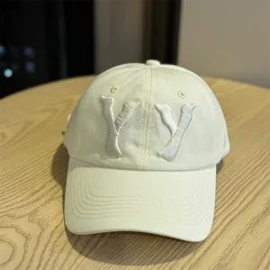 Detailed close-up view of the beige cotton baseball cap featuring stylish 3D embroidered YY letters.