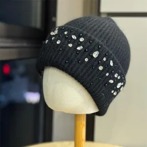 Vista dettagliata di un elegante berretto in maglia nera con strass scintillanti e perline.