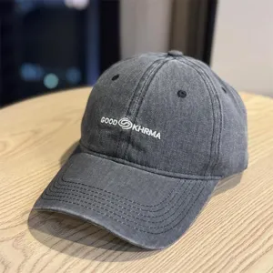 Detailed shot of washed vintage baseball cap, distressed fabric with embroidered text logo.