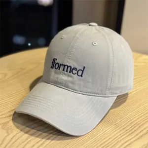 Close-up detail of the stylish grey baseball cap featuring neat 'fformed' embroidery design.