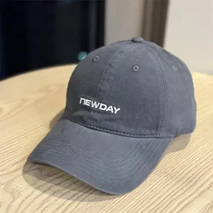 Close-up view of the washed cotton dark grey baseball cap showing embroidery detail and texture.