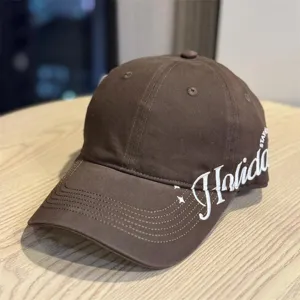 Detailansicht der braunen Baseballkappe mit breiter Krempe und weißer Seitlich-Bestickung.