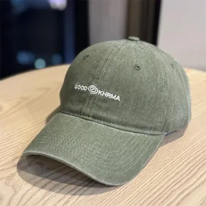 Detailed view of the washed green baseball cap featuring custom front embroidery and brim stitching.