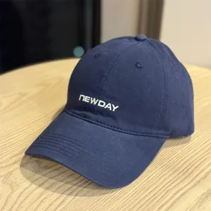 Close-up of the navy blue washed cotton baseball hat detail, soft crown and curved brim.