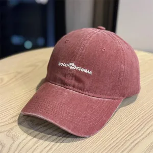 Close-up of vintage washed baseball cap with white embroidered text detail and curved brim.