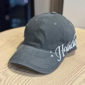 Nahaufnahme der dunkelgrauen Baseballkappe mit breiter Krempe und weißer Stickerei.