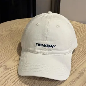 Detailed shot of a white washed cotton baseball cap with embroidered logo, casual outdoor style.