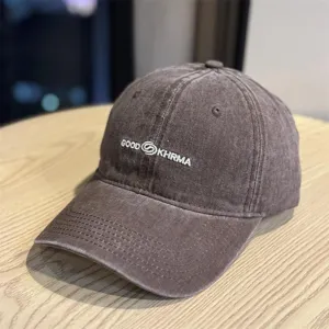 Detailed shot of vintage washed baseball cap with embroidered lettering and worn-in look.