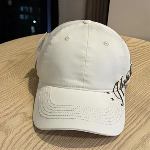 Detailansicht einer weißen Baseballkappe mit Seitenstickerei und gebogenem Schirm für Sonnenschutz.
