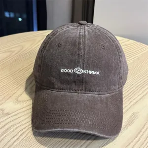 Detailed shot of a vintage distressed brown baseball cap with white embroidered text detail.