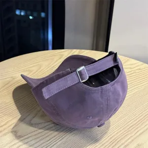 Purple cotton baseball cap with adjustable metal buckle and back tag detail for daily wear.