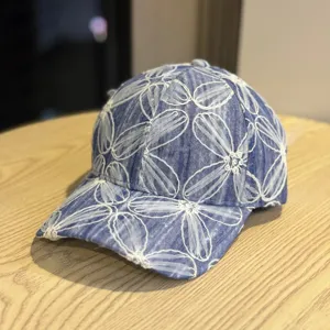 Jeans Baseballcap mit weißer Blumenstickerei, perfektes Detailbild für stylische Damen Sonnenhüte.