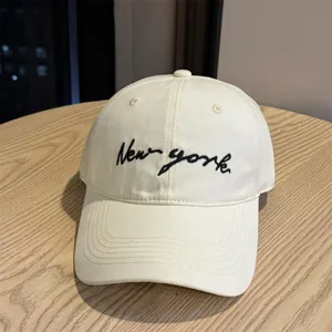 Classic beige women's baseball cap featuring chic black letter embroidery for sun protection.