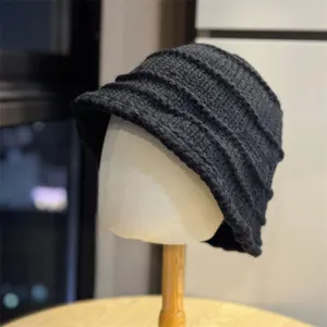 Detail view of the dark grey knit bucket hat, showcasing unique wrinkled texture and warm yarn.