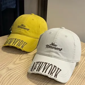 Detailed view of washed vintage baseball cap with distressed embroidery and letters.