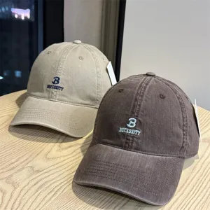 Detail shot of washed cotton baseball caps with stylish letter embroidery, casual unisex design.