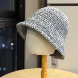 Vue detaillee du chapeau bob en tricot gris automne hiver, texture de laine confortable.