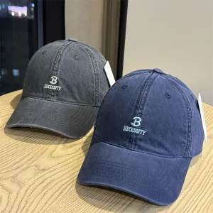 Detail of high quality washed cotton baseball caps with chic letter embroidery and curved brim.