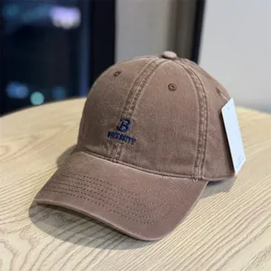 Vintage washed brown baseball cap with stylish blue letter embroidery for casual wear.